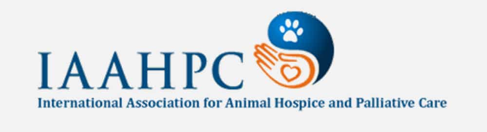 Logo for IAAHPC featuring the text "International Association for Animal Hospice and Palliative Care." The design includes a blue and orange palette with a paw print and a hand holding a heart, symbolizing compassionate care from veterinarians.
